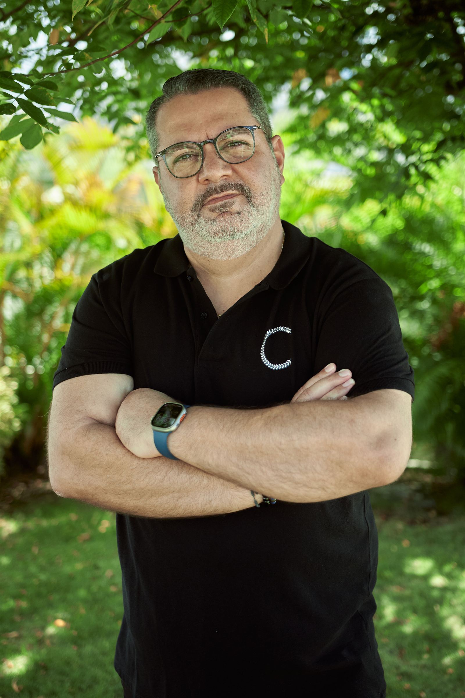 Ghassan Rizk, bras croisés, dans le jardin du bureau à Baie-Mahault